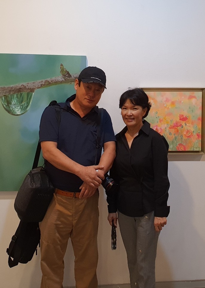 이번 작품전을 기획하고 준비한 이영수 회장(우측)은 매혹적이고 환상적인 양귀비와 이슬방울을 소재로 풀잎이나 꽃잎에 구슬처럼 맺혀 있는 이슬을 실제처럼 생생히 묘사하는 작업을 국내외에 널리 알린 화가이다. 취재 후 작품 앞에서 한 컷.