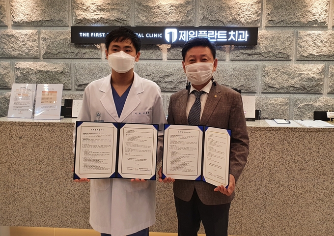 제일플란트치과 '이효선원장'(왼쪽), 영동시장주식회사 "이정관대표'(오른쪽) 협약식 후 기념촬영을 하고 있다.
