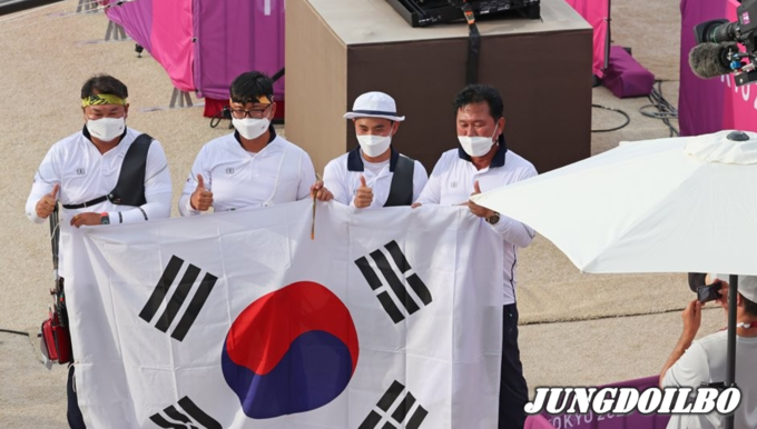 26일 일본 유메노시마 공원 양궁장 도쿄올림픽 남자 단체전 결승. 우승 확정 후 김제덕, 김우진, 오진혁이 태극기를 펼치고 있다.