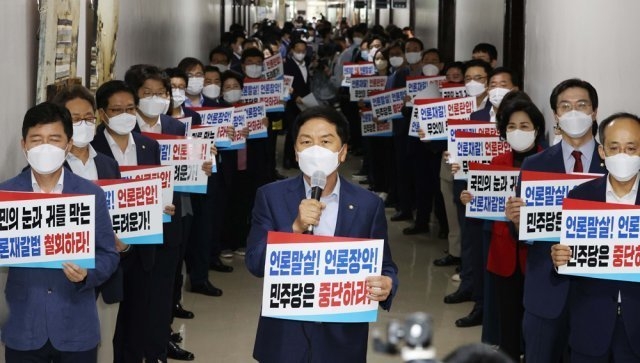 국민의힘 소속 50여 의원들이 24일 서울 여의도 국회 법제사법위원회 회의실 앞에서 여당의 언론중재법 개정안 강행을 규탄하는 손팻말을 들고 있다. 