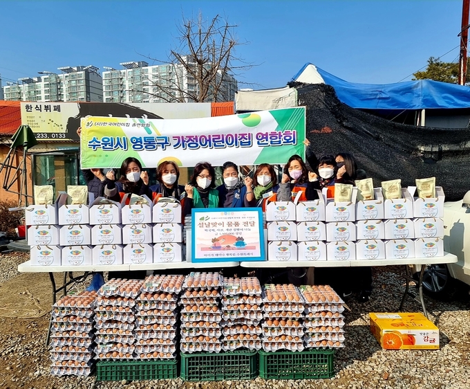 수원시어린이집연합회(한어총) 영통가정분과' 정용숙 원장(지역장)과 어린이집 원장들, '(사)행복캄 김미선 여성회장이 '수원시노인회'에 물품을 전달하며 기념촬영을 하고 있다.