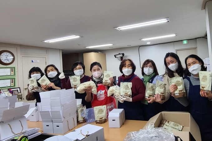 '수원시어린이집연합회(한어총) 영통가정분과' 어린이집 원장들과 (사)행복캄 김미선 여성회장이 선물꾸러미를 포장하는 모습