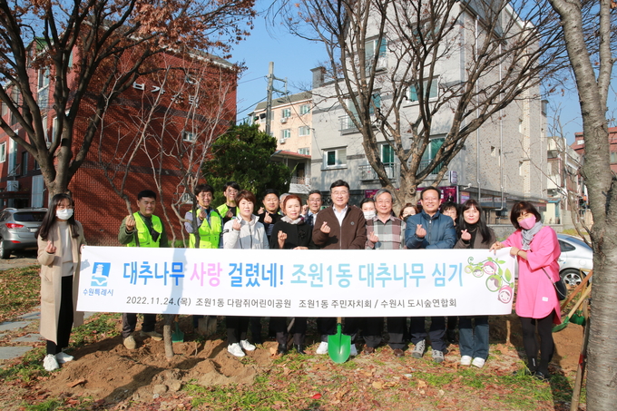 최상규 수원시 장안구청장(앞줄 오른쪽에서 5번째)을 비롯한 수원시 공원녹지사업소·수원시도시숲연합회 관계자, 조원1동 지역주민 등이 기념촬영을 하고 있다.