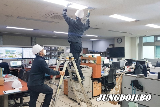 시 관계자가 에너지 절약 실천을 위해 청사 내 형광등을 빼고 있다