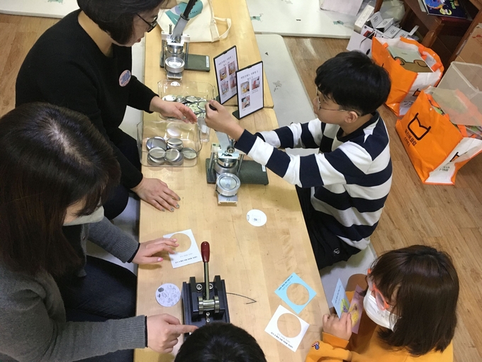 용인특례시가 지역아동센터에서 찾아가는 디지털창작소를 운영했다_ 버튼 프레스를 이용해 직접 디자인한 뱃지를 만드는 모습