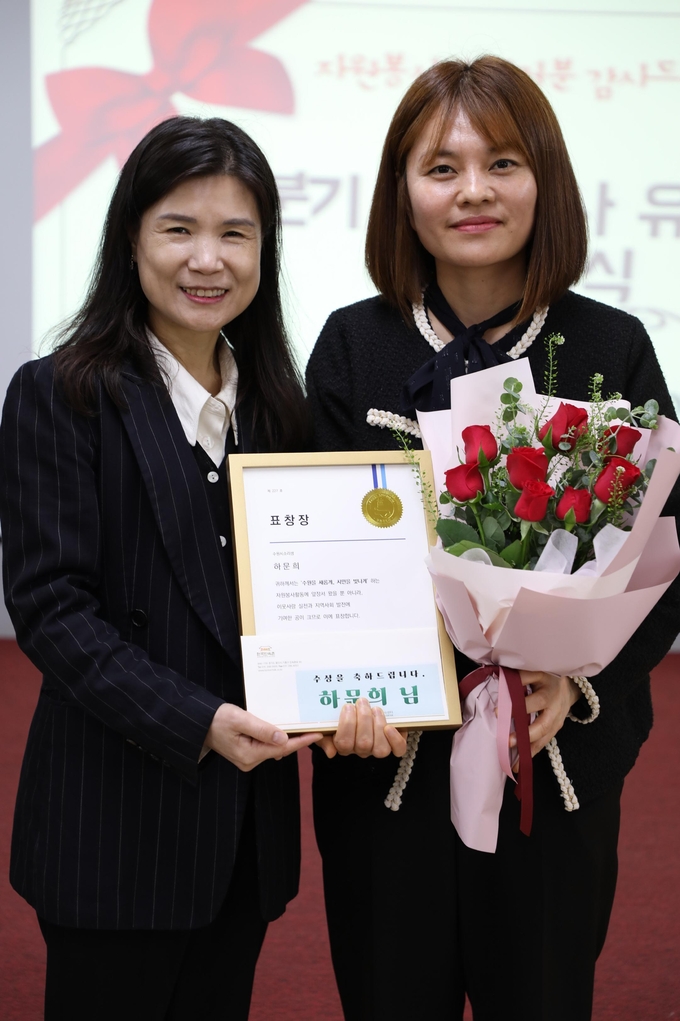 최영화 수원시자원봉사센터장이 수원시장상 수상자인 ‘수원시소리샘’ 봉사단 소속 하문희(오른쪽)씨와 기념 촬영을 하고 있다.
