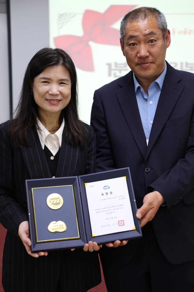 최영화 수원시자원봉사센터장과 경기도지사상을 수상한 ‘수원교통안전지원단수원지대’ 봉사단 소속 안보현(오른쪽)씨가 기념 촬영을 하고 있다.