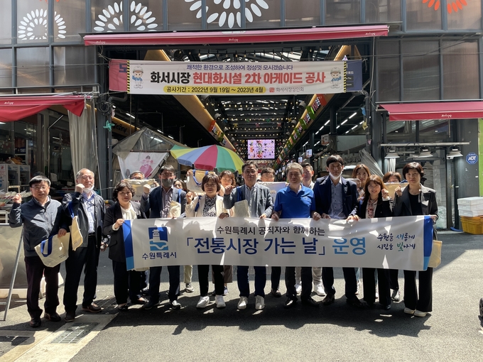 ‘전통시장 가는 날’ 행사에 참여한 경제정책국 직원들이 화서시장에서 함께하고 있다.