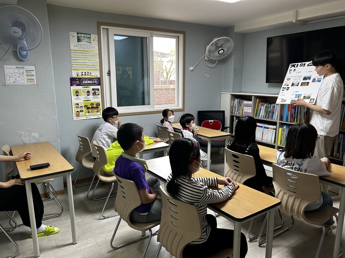 수원시자원봉사센터와 청년팀플 수원대능동봉사동아리가 지난 15일 수원 고색동에 있는 밝은별 지역아동센터에서 초등학교 저학년을 대상으로 경주, 전주, 제주도의 지역문화와 역사를 소개하고, 실제 놀거리를 체험하도록 하고 있다.
