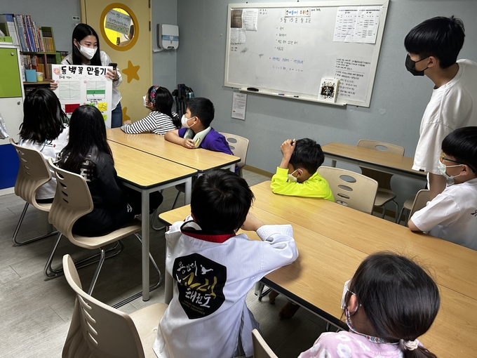 수원시자원봉사센터와 청년팀플 수원대능동봉사동아리가 지난 15일 수원 고색동에 있는 밝은별 지역아동센터에서 초등학교 저학년을 대상으로 경주, 전주, 제주도의 지역문화와 역사를 소개하고, 실제 놀거리를 체험하도록 하고 있다.