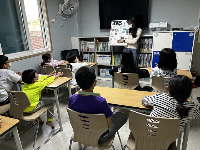 수원시자원봉사센터와 청년팀플 수원대능동봉사동아리가 지난 15일 수원 고색동에 있는 밝은별 지역아동센터에서 초등학교 저학년을 대상으로 경주, 전주, 제주도의 지역문화와 역사를 소개하고, 실제 놀거리를 체험하도록 하고 있다.
