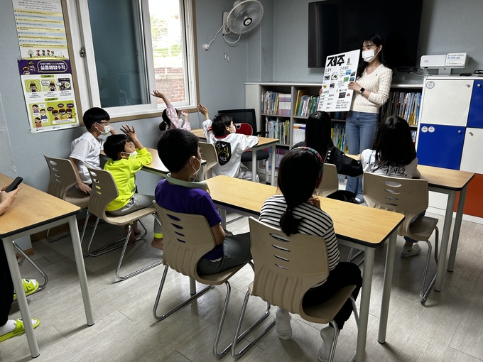 수원시자원봉사센터와 청년팀플 수원대능동봉사동아리가 지난 15일 수원 고색동에 있는 밝은별 지역아동센터에서 초등학교 저학년을 대상으로 경주, 전주, 제주도의 지역문화와 역사를 소개하고, 실제 놀거리를 체험하도록 하고 있다.