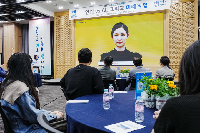 토크콘서트 참석자들이 AI 휴먼과 대화를 나누고 있다.