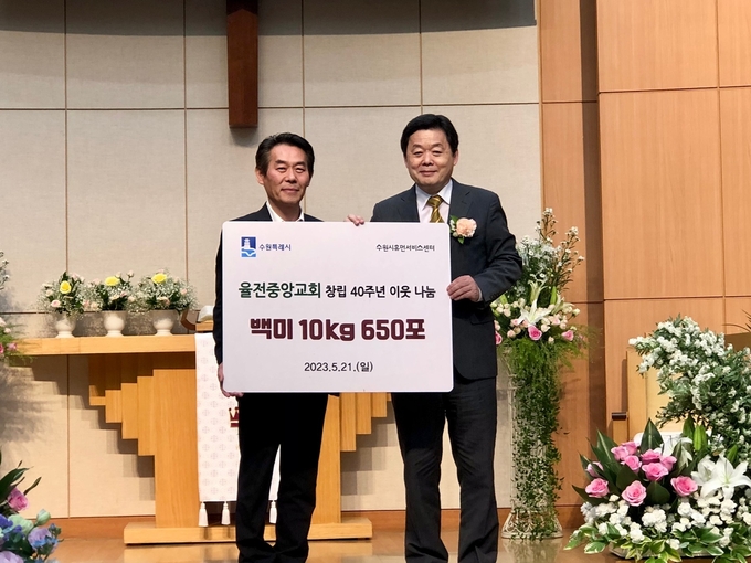 신준호 율전중앙교회 담임목사(오른쪽)과 최승래 수원시 복지여성국장이 전달식 후 기념촬영을 하고 있다.