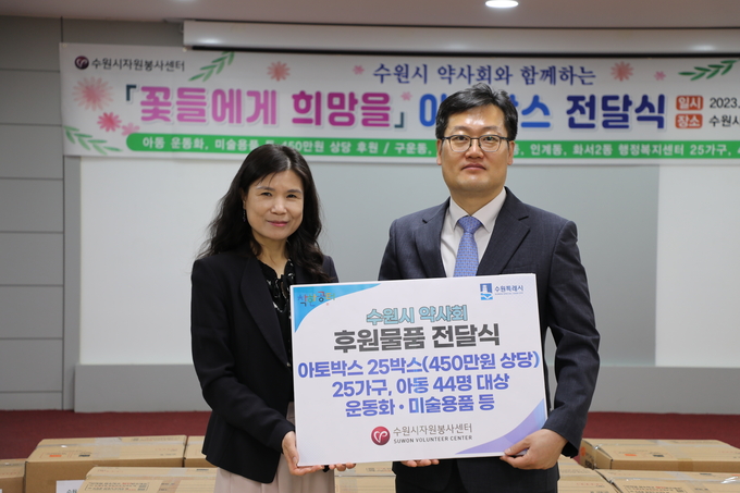 최영화(왼쪽) 수원시자원봉사센터장과 김호진 수원시약사회장이 24일 센터 4층에서 후원물품 전달식을 마친 뒤 기념 촬영을 하고 있다.