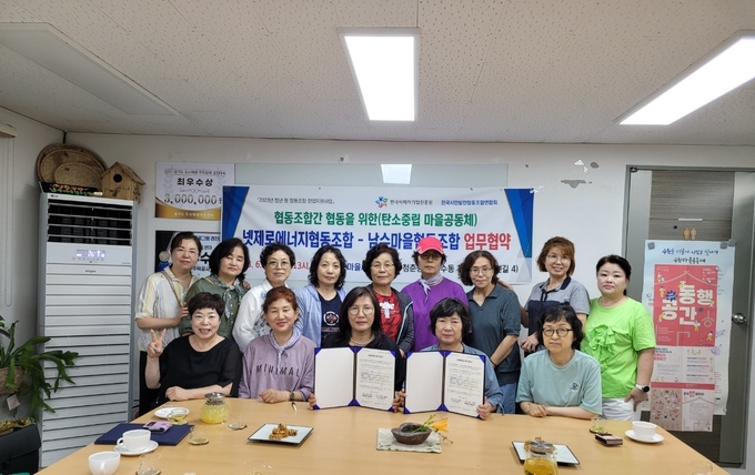 구운마을사랑의 넷제로에너지협동조합과 남수마을협동조합간 탄소중립에 따른 마을공동체 업무협약후 기념촬영을 하고 있다