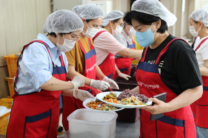박광온 더불어민주당 원내대표 부인 김희정(왼쪽에서 두 번째)씨와 이재준 수원특례시장 부인 이지영(왼쪽 맨 앞)씨가 수원역 무료 급식시설에서 경기교육자원봉사단체협의회 봉사자들과 반찬 배식 봉사활동을 하고 있다.