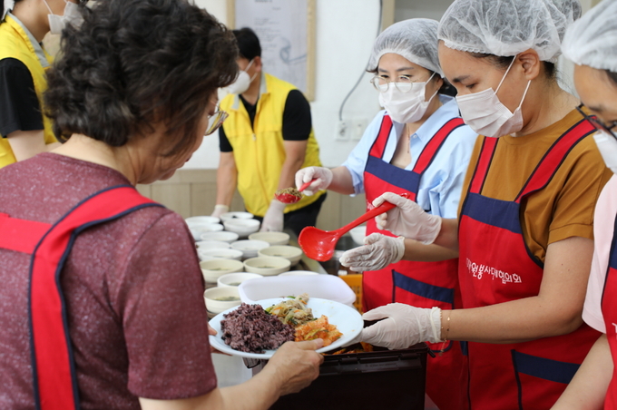 박광온 더불어민주당 원내대표 부인 김희정(오른쪽에서 두 번째)씨와 이재준 수원특례시장 부인 이지영(오른쪽에서 세 번째)씨가 수원역 무료 급식시설에서 경기교육자원봉사단체협의회 봉사자들과 반찬 배식 봉사활동에 참여하고 있다.