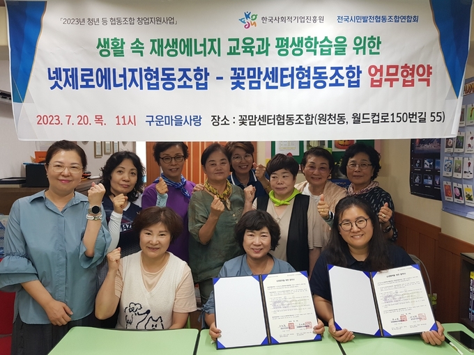 구운마을사랑의 넷제로에너지협동조합과 수원 영통구에 위치한 꽃맘센터협동조합은 7월 20일 재생에너지, 환경교육 등과 탄소중립 평생학습을 위한 업무협약에 참석해 기념촬영을 하고 있다.