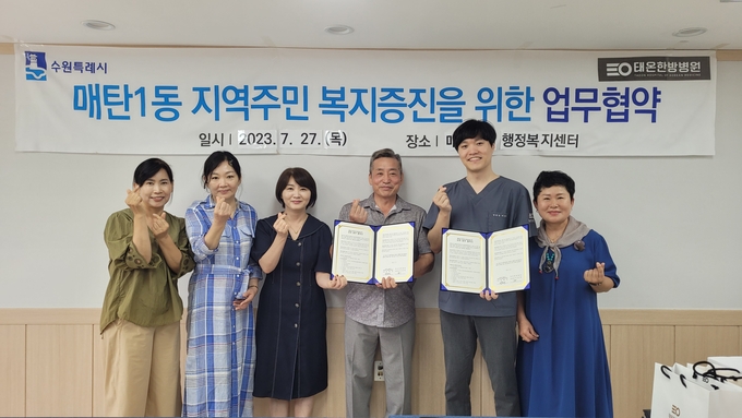 (왼쪽부터)매탄1동 행정복지센터 맞춤형복지팀장 유미선, 주민자치회 사무장 김미옥, 동장 양황경, 주민자치회 회장 좌성태, 태온한방병원 대표원장 이경재, 홍보실장 고정희 협약식 후 함께 하고 있다.