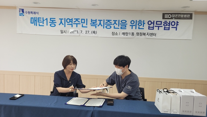 협약서 작성하는 양황경 매탄1동옹장(왼쪽), 이경재 태온한방병원 한방대표원장(오른쪽)
