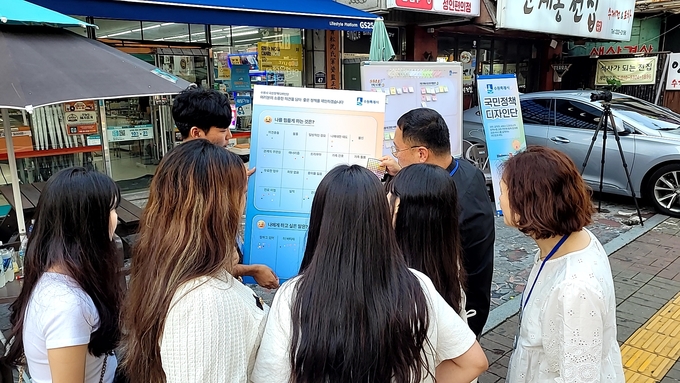 청년들이 설문조사에 참여하고 있다.