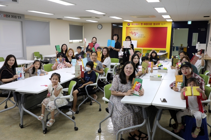 다문화 가족들이 26일 수원시자원봉사센터 4층 대강당에서 직접 만든 ‘한지 북아트’를 들고 기념 촬영을 하고 있다.
