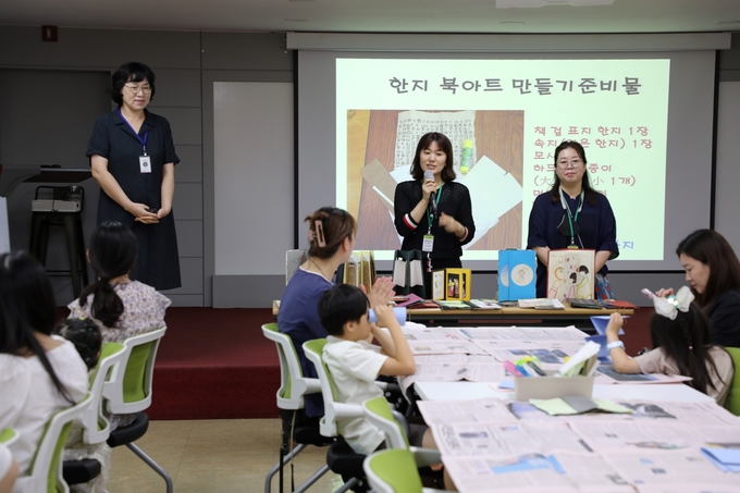 26일 수원시자원봉사센터 4층 대강당에서 강사진들이 다문화 가족들에게 ‘한지 북아트’ 만들기를 설명하고 있다.