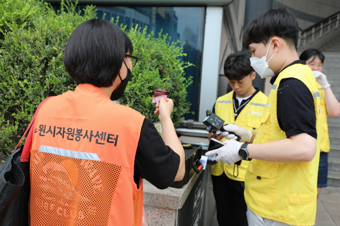 수원시자원봉사센터와 직장인, 대학생으로 구성된 ‘청년팀플 수원청년봉사단’은 27일 오후 수원역 앞에서 화장실 불법 촬영을 점검하기 위해 적외선 탐지장비를 다루고 있다.