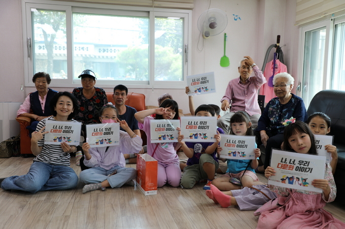 지난 23일 초등학생들이 ‘나 너 우리 다문화이야기’ 프로그램에서 일본 화과자인 ‘오하기’를 만들어 서둔동 벌터경로당 어르신들에게 전달한 뒤 기념 촬영을 하고 있다.