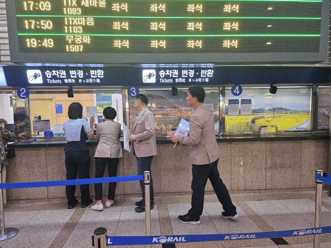 수원시 베테랑 공무원들이 지난 20일 수원역에 ‘수어통역 화상통화 서비스’ 탁상용 배너를 설치하고 있다
