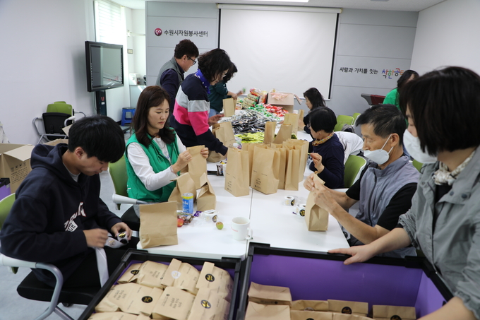 수원시여성리더회와 개인 봉사자들이 5일 수원시자원봉사센터에서 간식 2000개를 포장하고 있다.