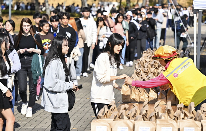 지난 2일 수원 성균관대학교 자연캠퍼스에서 열린 ‘찾아가는 사랑의 밥차’에 참여한 대학생들이 줄지어 서 있다.