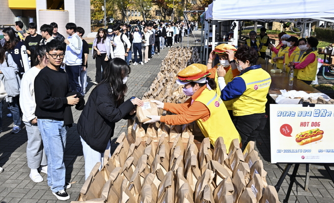 지난 2일 수원 성균관대학교 자연캠퍼스에서 열린 ‘찾아가는 사랑의 밥차’에 참여한 대학생들이 줄지어 서 있다.