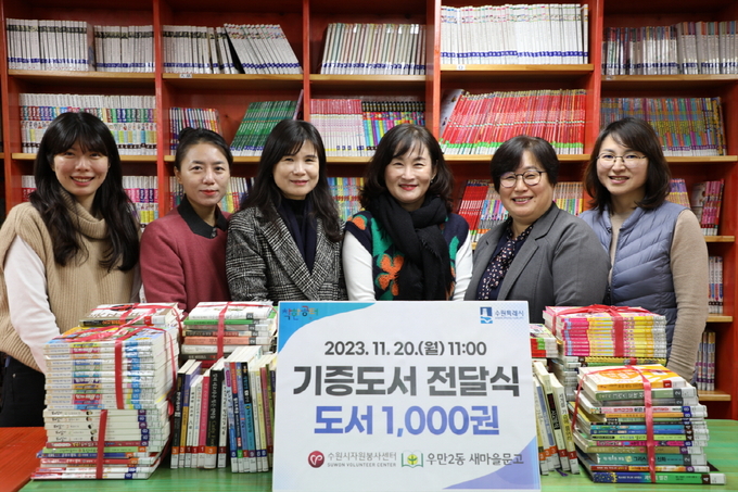 우만2동 새마을문고회는 20일 오전 서고에서 책 1000권을 수원시자원봉사센터에 기탁했다. 정유선(오른쪽에서 세 번째) 새마을문고회장, 최영화(왼쪽에서 세 번째) 수원시자원봉사센터장, 정상빈(오른쪽에서 두 번째) 우만2동장 등이 기념촬영을 하고 있다.