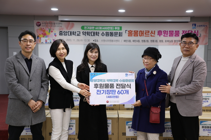 한일권(맨 오른쪽) 중앙대학교 약학대학 수원동문회장과 관계자, 최영화(가운데) 수원시자원봉사센터장 등이 전기장판 전달식을 마친 뒤 기념 촬영을 하고 있다.