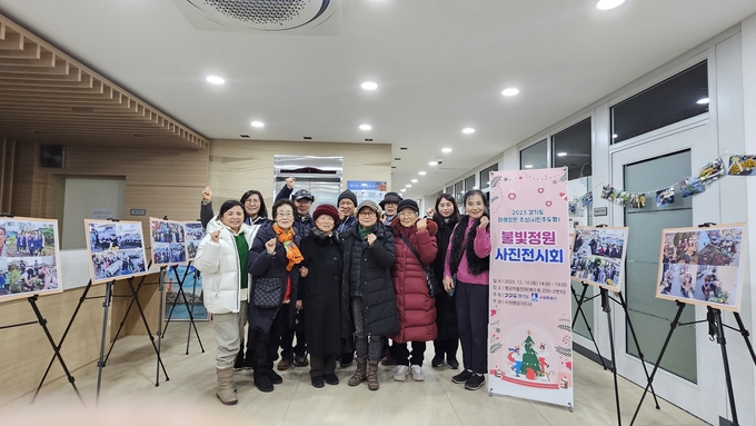 지난 12월 16일 행궁마을정원과 행궁동 어울림센터에서 불빛정원 사진전시회 참석자들이 기념촬영을 하고 있다.
