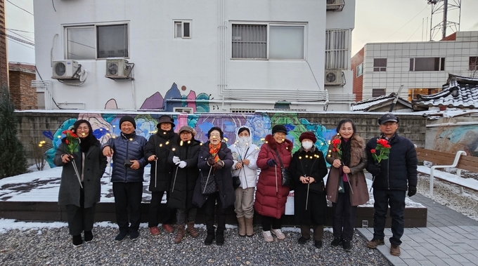 지난 12월 16일 행궁마을정원 불빛정원 사진전시회 참석자들이 기념촬영을 하고 있다.