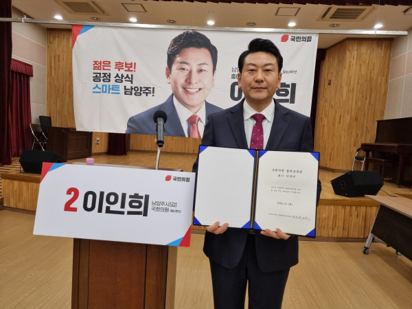 이인희 예비후보가 불체포특권 서약서를 들고 기념사진을 찍고 있다.