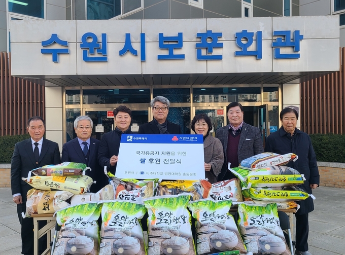 강신 아주대학교 경영대학원 총동문회장(가운데), 박란자 수원시 복지여성국장(오른쪽 3번째), 수원시보훈회관 관계자 등이 전달식 후 기념촬영을 하고 있다.