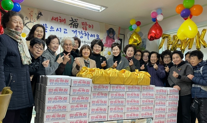 전몰군경미망인회 수원시지회 회원들과 국가보훈대상자들이 떡 나눔 행사 후 함께하고 있다.