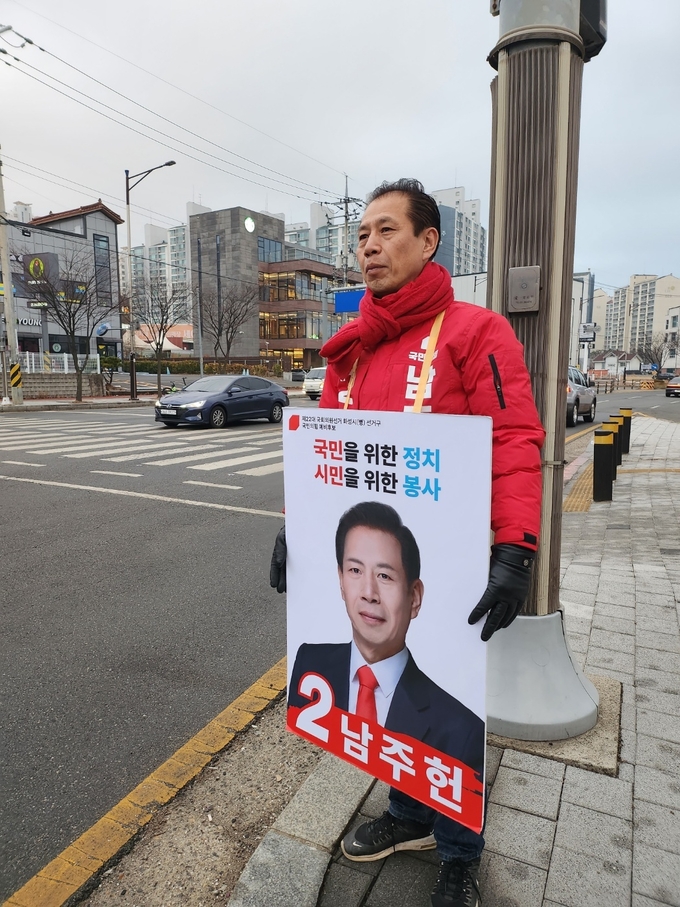 남주헌 예비후보가 거리에서 아침 인사를 하고 있다.