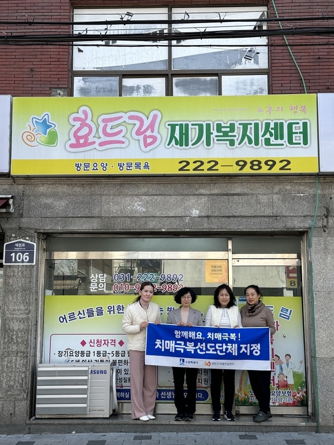 치매극복선도단체로 지정한 효드림재가복지센터에 현판을 전달하는 모습.