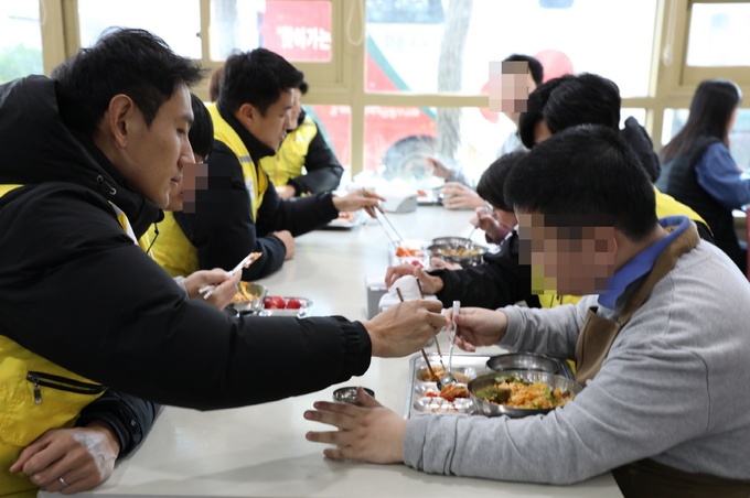 수원FC 지동원 선수가 수원시장애인종합복지관 식당에서 장애인의 식사를 돕고 있다.