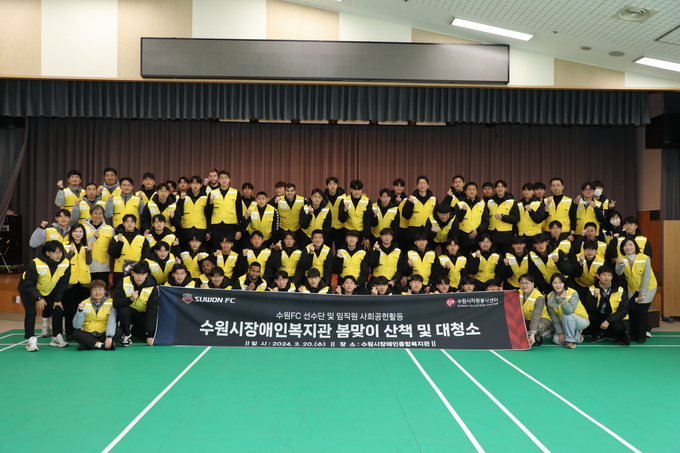 수원FC 선수와 임직원들이 수원시장애인종합복지관에서 대청소와 장애인과 산책하기 등 봉사활동을 펼친 뒤 기념 촬영을 하고 있다.