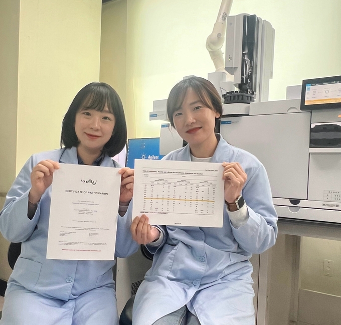 용인특례시 농업기술센터 관계자들이 영국 식품환경연구청의 잔류농약 분석 평가지를 들고 기념촬영을 하고 있다