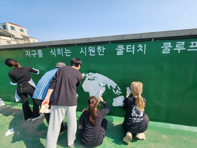 수원청년자원봉사단 경기대 사이 청년봉사자들이 지난 18일 쿨루프 사업 대상건물인 수원 곡반정경로당 옥상에서 벽화그리기 봉사활동을 펼치고 있다.