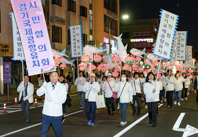 경기국제공항유치시민협의회 회원들이 ‘2024 수원연등축제’ 연등행렬에 참여하고 있다.