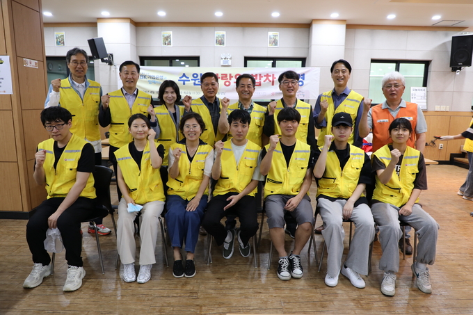 최순호(뒤쪽 맨 왼쪽) 수원FC 단장 등 수원시 공공기관장과 이재준 수원시장의 부인 이지영(앞줄 왼쪽에서 세 번째)씨가 27일 ‘사랑의 밥차’에서 청년봉사단과 기념 촬영을 하고 있다.