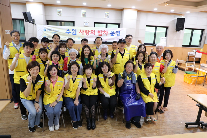 최순호(맨 뒤줄 맨 왼쪽) 수원FC 단장 등 공공기관장과 이재준 수원시장의 부인 이지영(맨 앞줄 왼쪽에서 세 번째)씨, 수원시여성리더회 등 봉사자들이 27일 ‘사랑의 밥차’에서 기념 촬영을 하고 있다.
